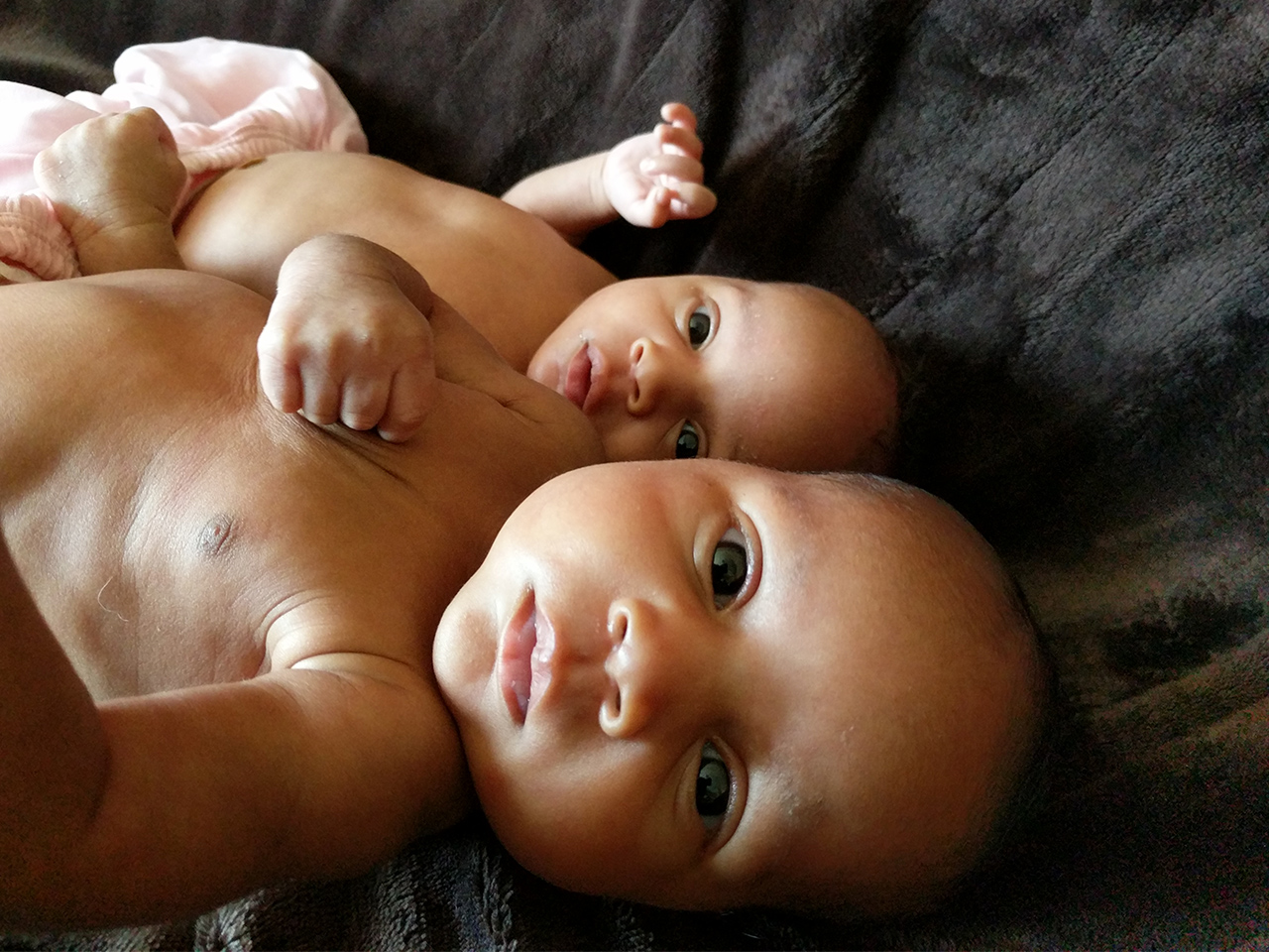 Twin babies laying in bed