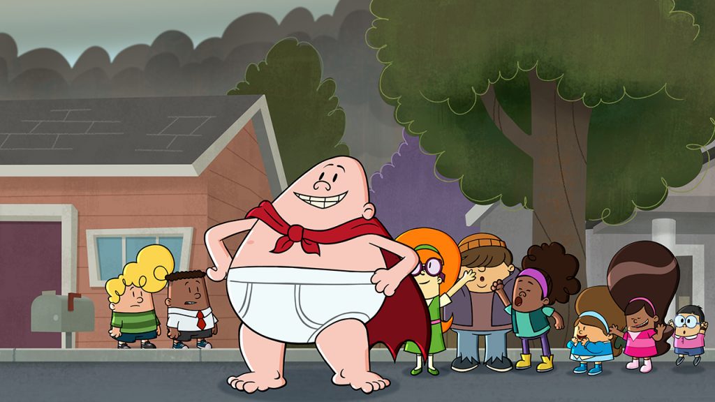 Promo image for The epic Adventures of Captain Underpants showign the hero himself standing on the street with some kids