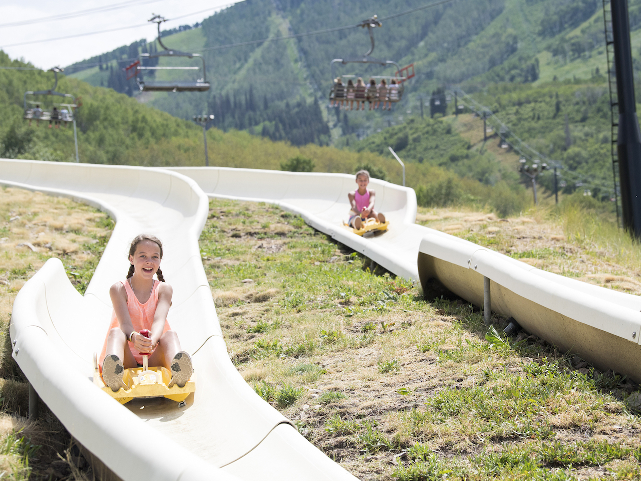 kids tubing down a mountain in summer