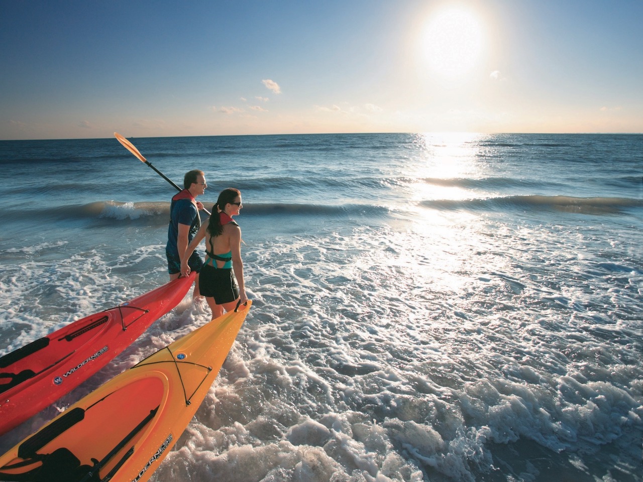 couple taking kayaks in ocean