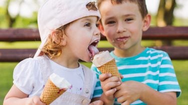 Cute little boy shares ice cream with his sister