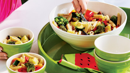 bowl with tube pasta, broccoli, zucchini and red peppers