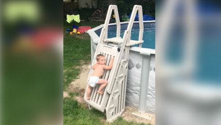 Kid climbing a locked pool ladder