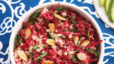 A grain bowl filled with quinoa beets and sliced almonds