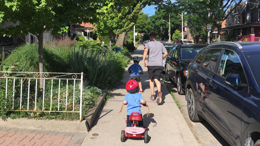 Dad running in a neighbourhood with kids