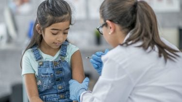 Girl getting vaccinated by doctor