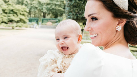 Prince Louis laughing while being held by Kate Middleton