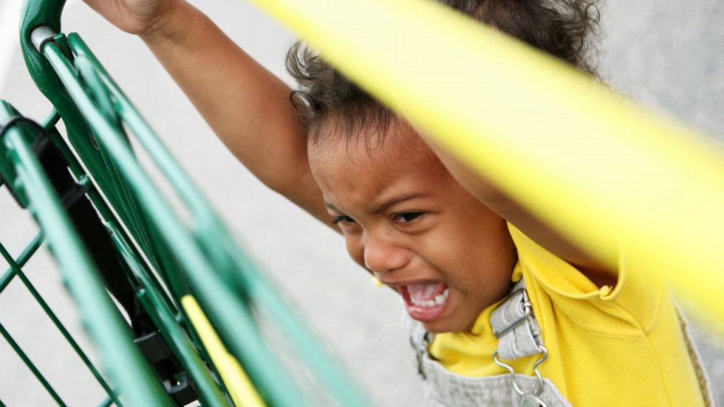 Child crying, hanging off shopping cart