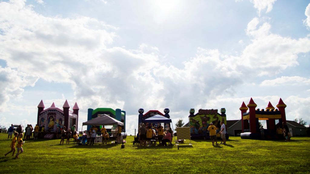 Five bouncey castles in a field during Garrett's celebration of life