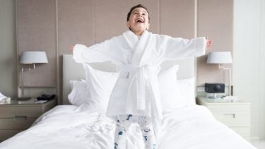 kid jumping on hotel room bed