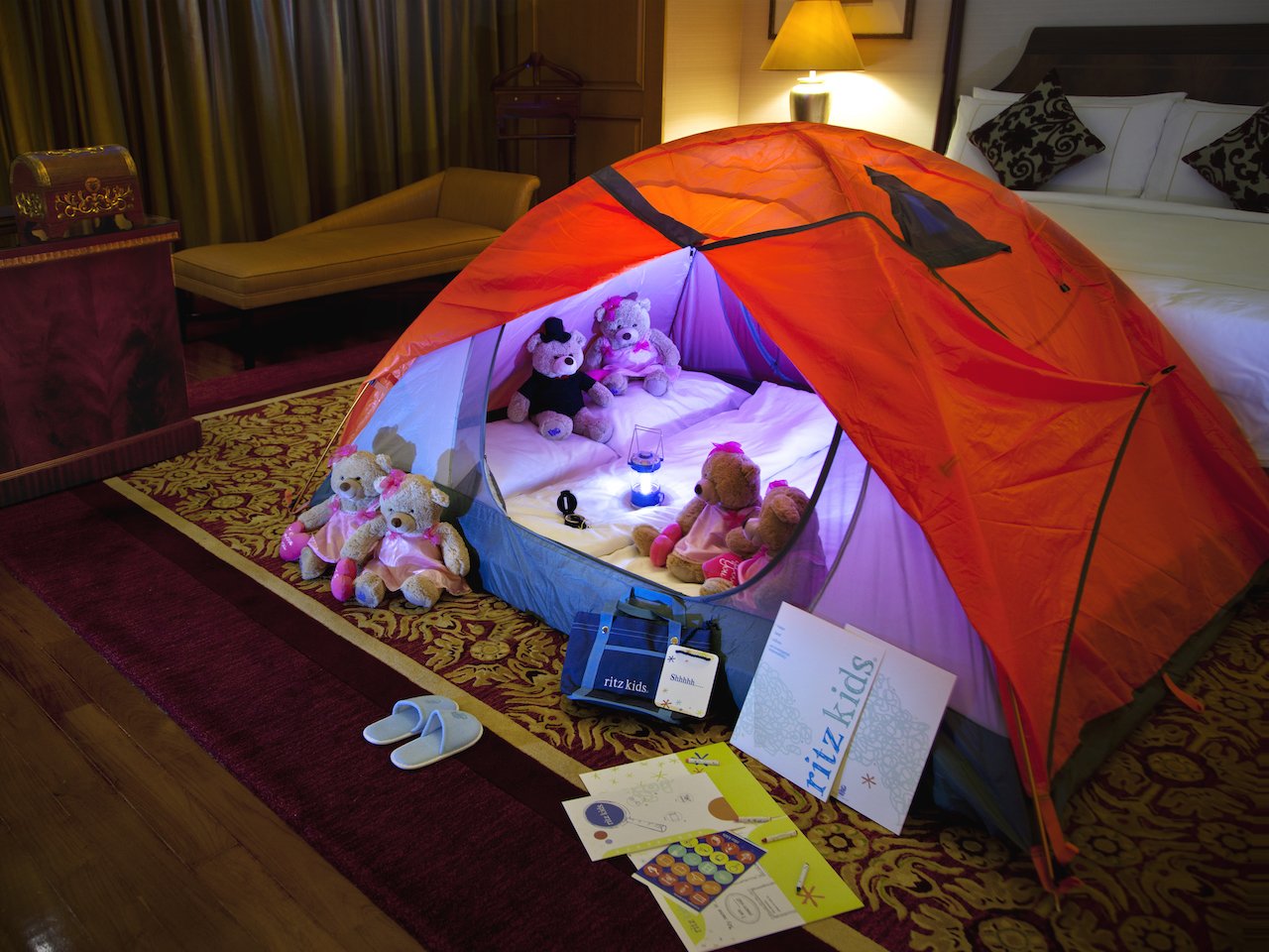 tent set up in hotel room with toys and flashlight
