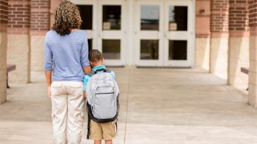 A mom and her son standing outside the school doors