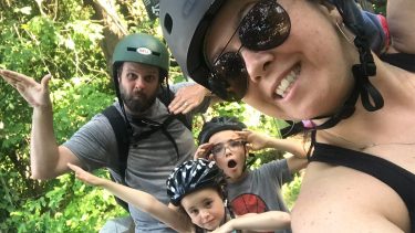 A family posing in helmets while on a bike ride