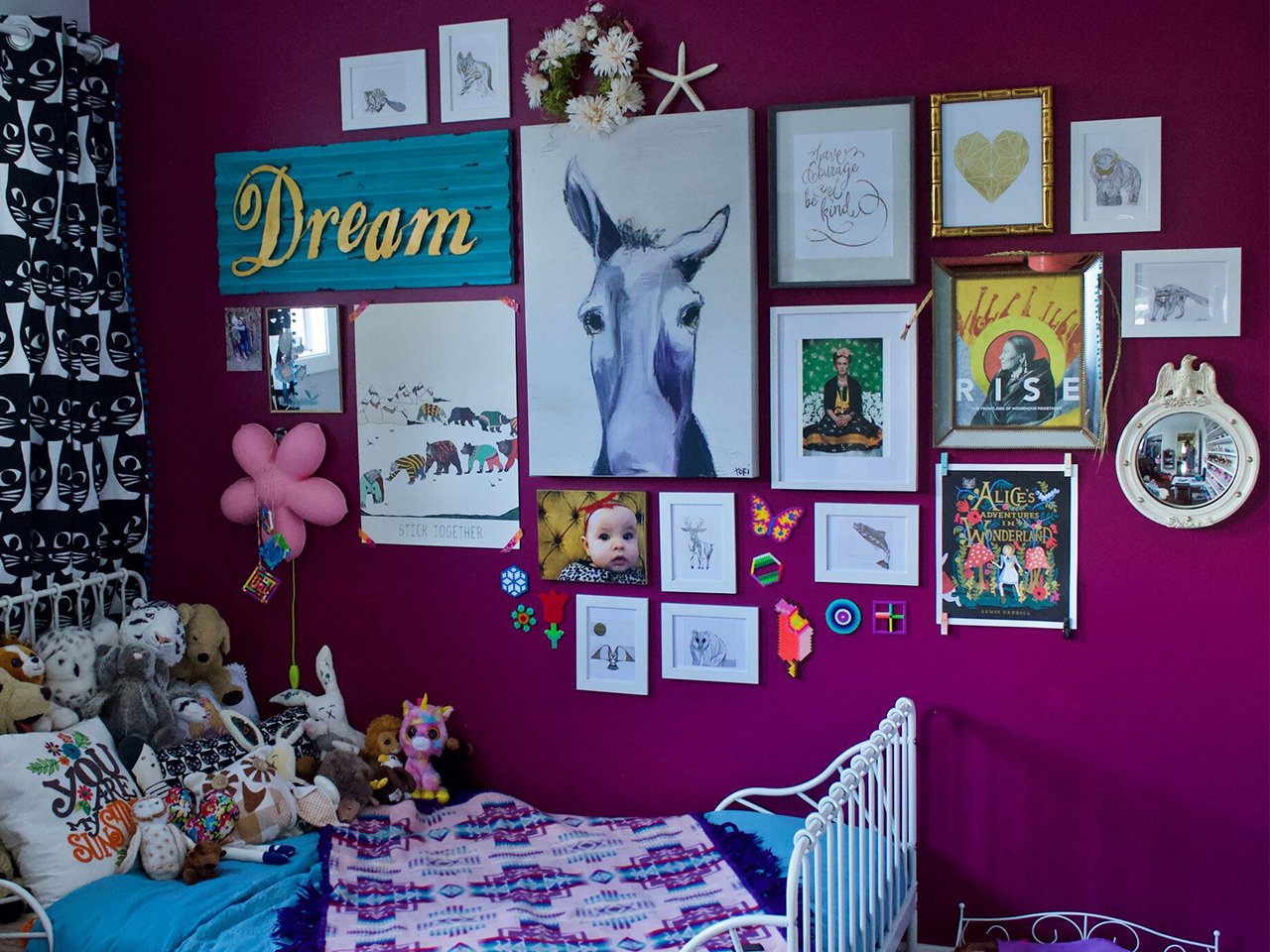 A pink bedroom decorated with an art gallery wall