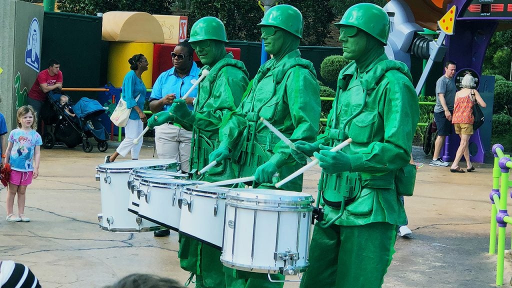 Drummers dressed up as Army men perform on the sidewalk
