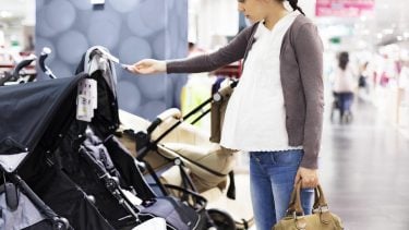 Pregnant woman shopping for strollers