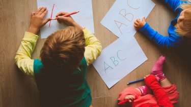 A group of kids writing their ABCs on paper