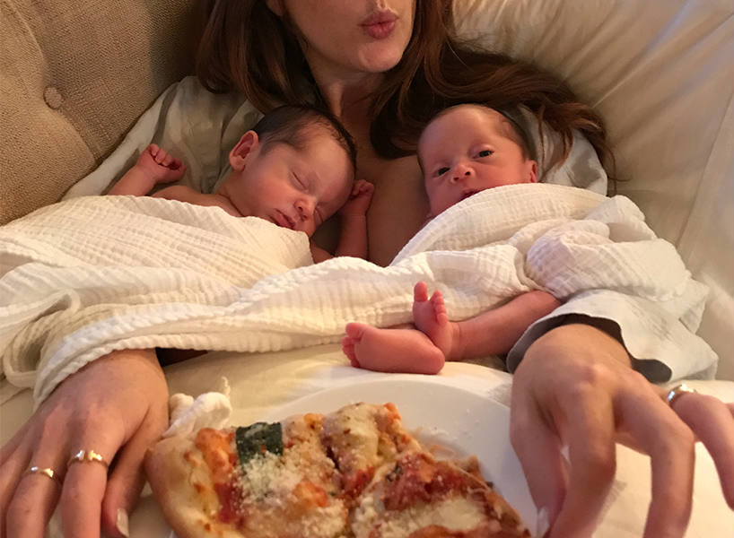 Jessi Cruickshank eating pizza with her twins on her lap
