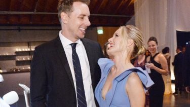 Kristen Bell and Dax Shepard looking at each other and laughing on a red carpet