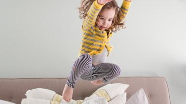 A little girl jumping on the bed