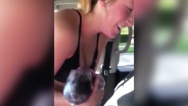 Mother in car holds newborn baby