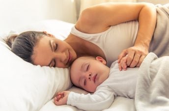 Mom sleeping in bed with her baby