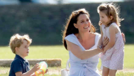 Kate Middleton tickling Princess Charlotte while Prince George plays with a slinky