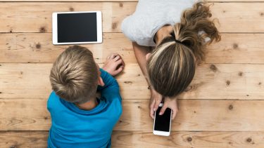 Two kids looking at Apple screens