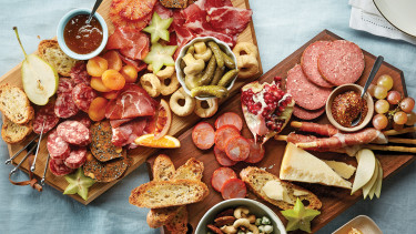 two platters covered in meats, breads and snacks
