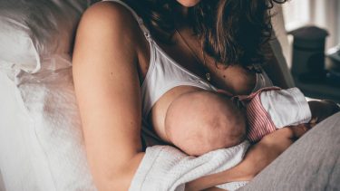 A mother breastfeeds her newborn.