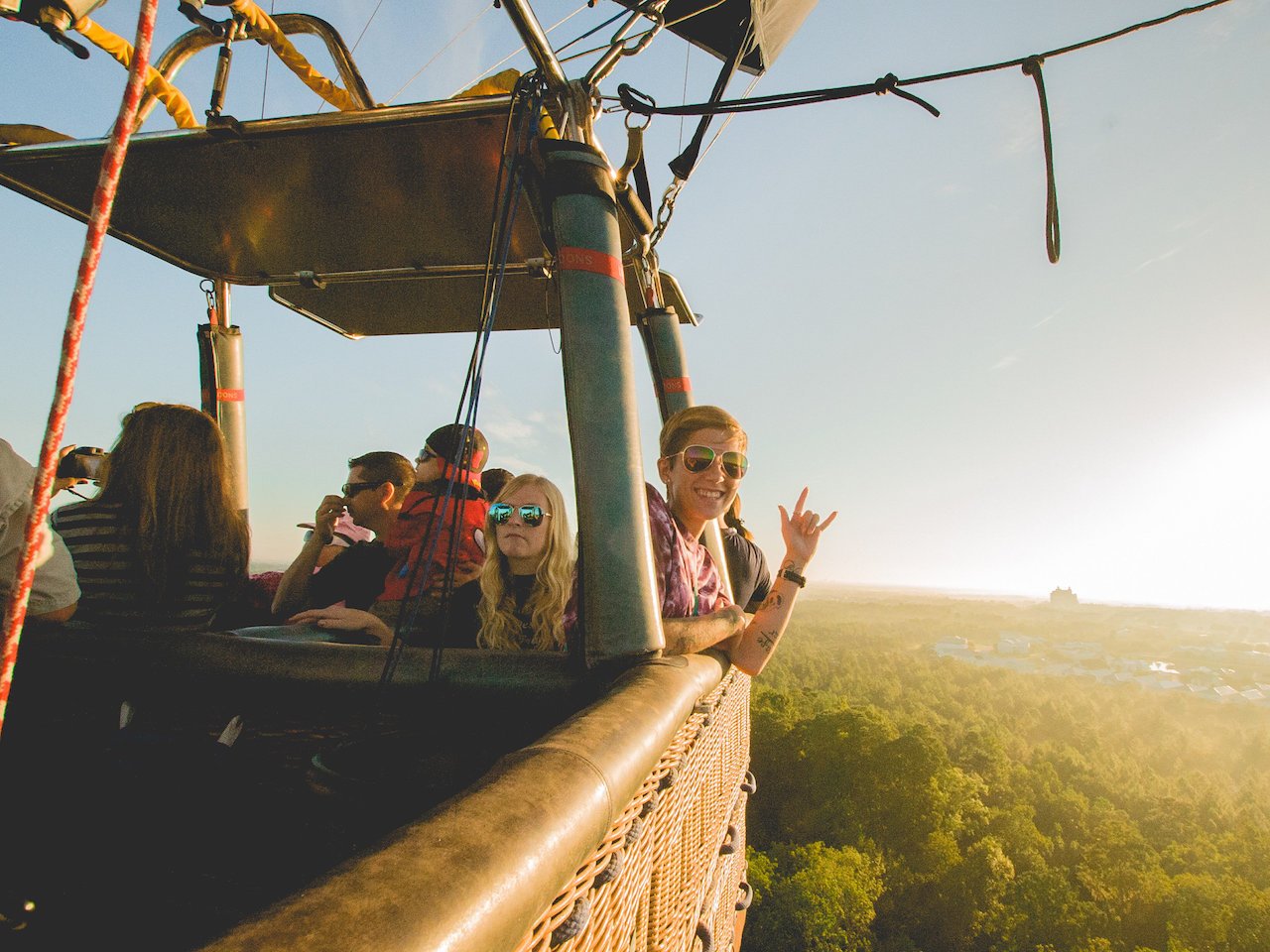 people waving from inside a hot air balloon