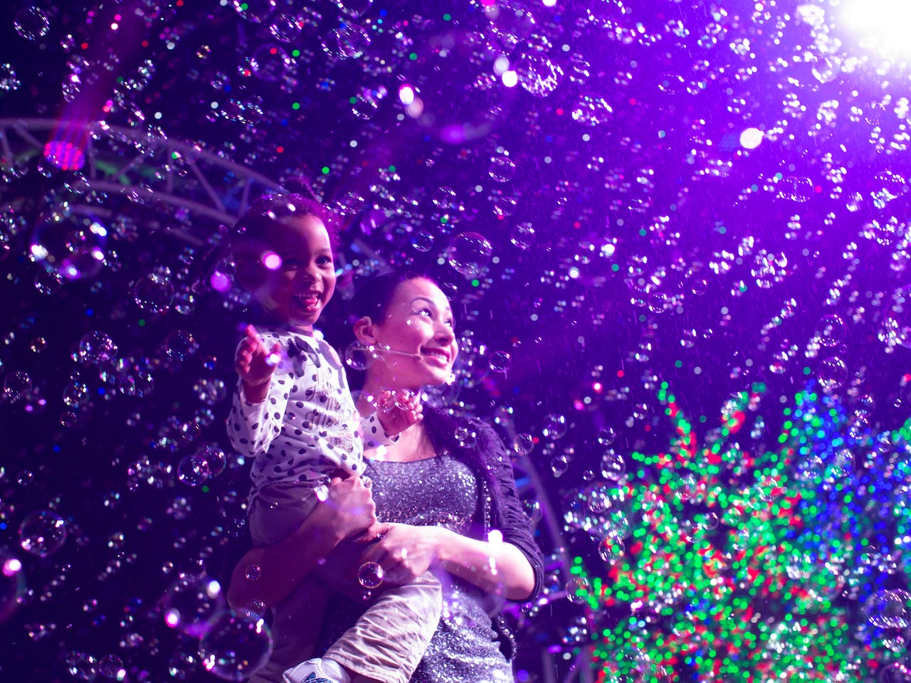 a mother and child surrounded but a cloud of bubbles