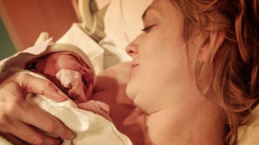 mom holding baby in hospital bed