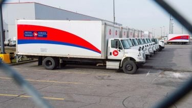 A Canada Post delivery van sitting in a parking lot