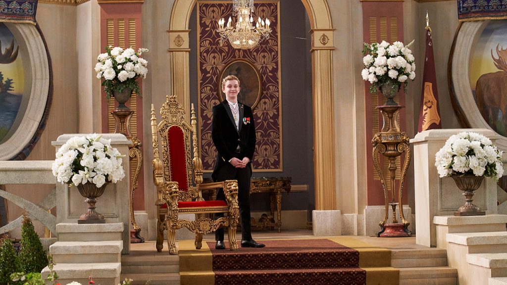Promo image for Prince of Peoria a Christmas Moose Miracle showing a boy in a suit standing next to a fancy throne