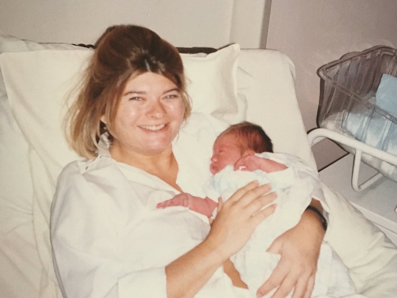 A mom holding her baby in the hospital bed after giving birth