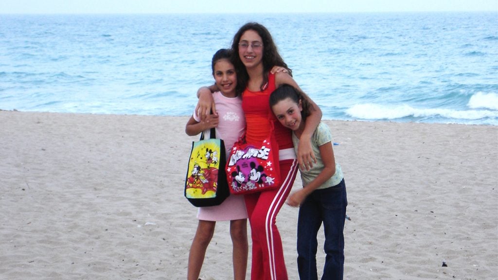 three sisters posing on the beach