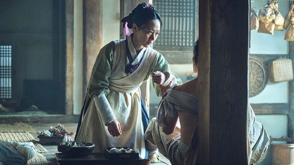 Promo image for Kingdom showing a woman in a kimono kneeling to help someone