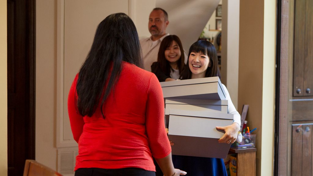 Promo image fot Tidying Up with Marie Kondo showing a family walking into a house with boxes