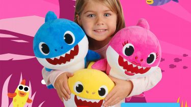 Little girl holding shark dolls