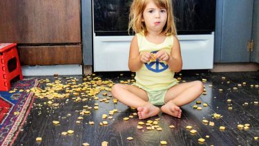 little girl sitting on the floor surrounded by crackers
