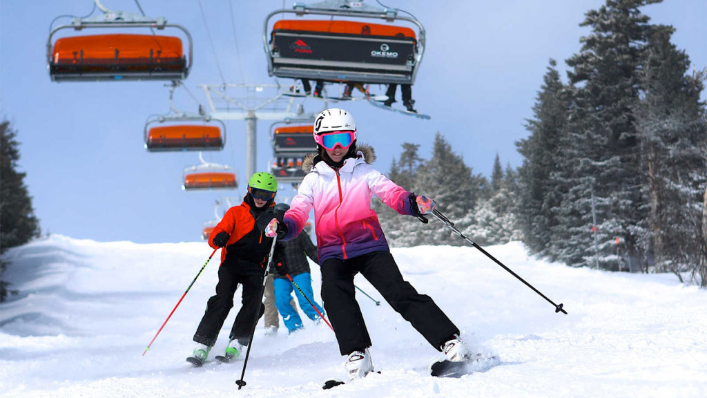 kids skiing under ski lift
