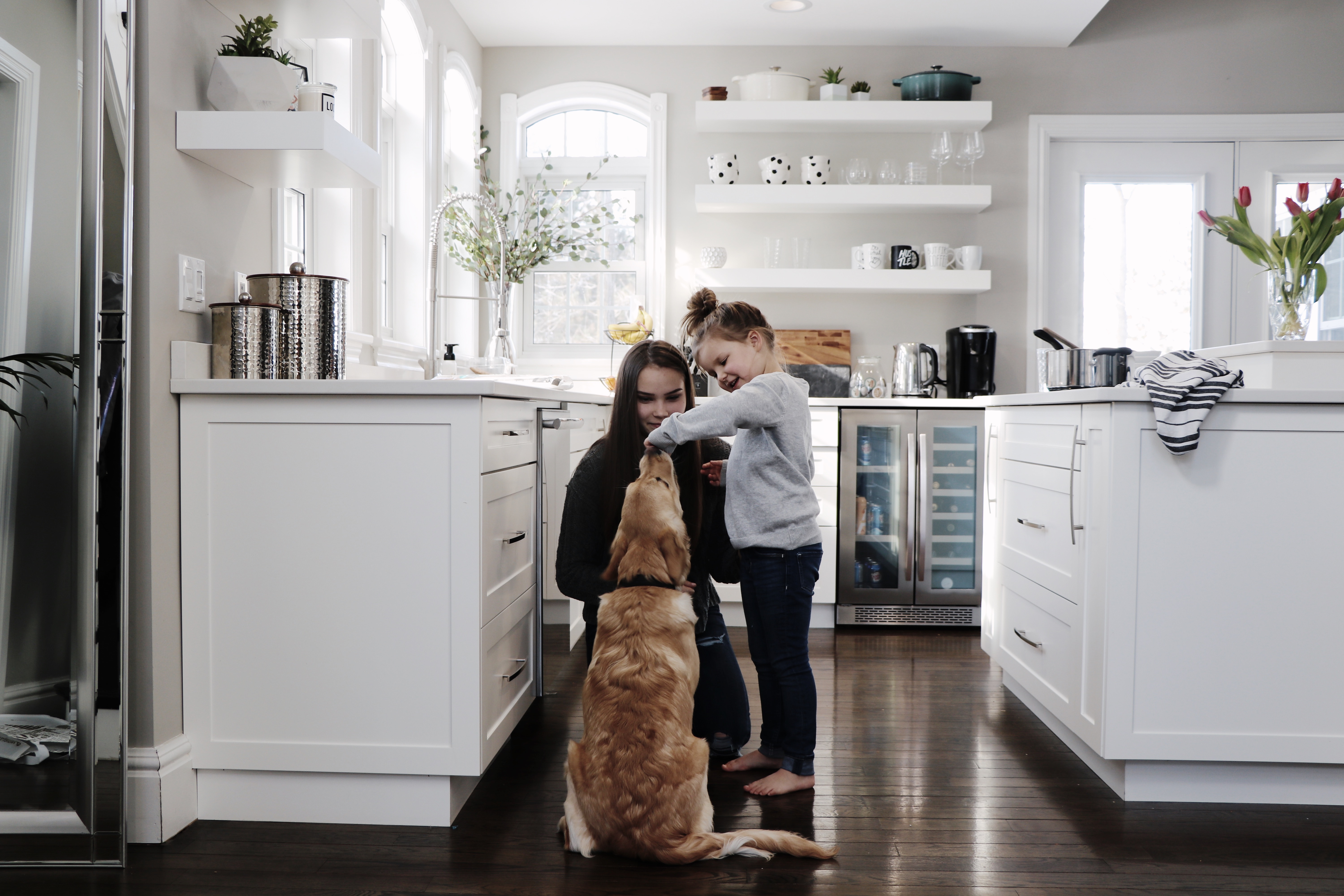 Mom and daughter in kitchen with family dog