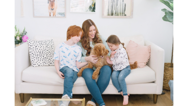 Mother and kids on the couch with family dog