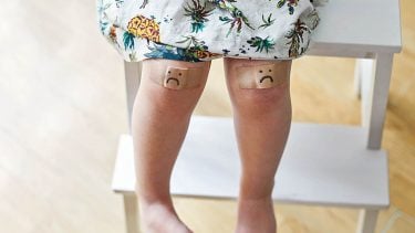 Toddler legs with a bandage on each knee