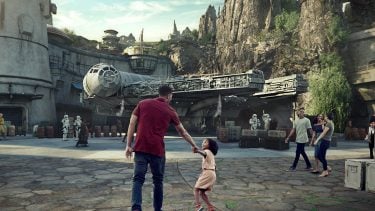 Little girl pulling her dad through the new Disney Star Wars Land