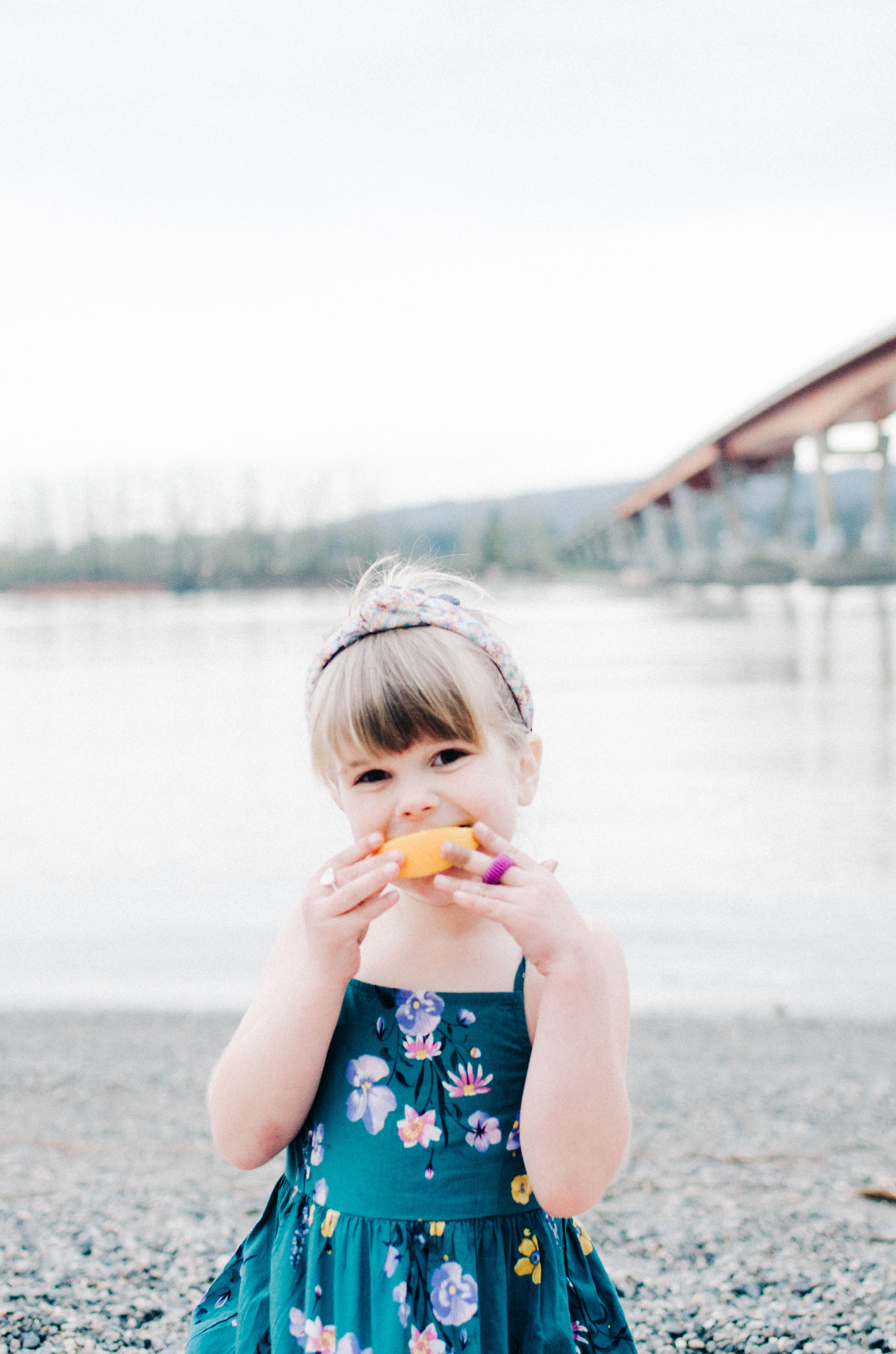 Codi Lynn's daughter eating an orange slice by the water