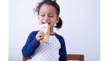 Photo of Marielle's daughter smiling and drinking a SunRype Fruit Plus Veggies juice box