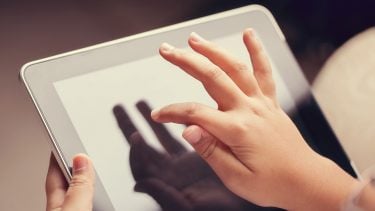 Close up of a young boys hands using a digital tablet.