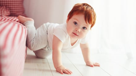 cute toddler baby getting off the bed, crawling at home